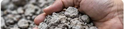 A hand holding pieces of aggregate as an example of material evidence