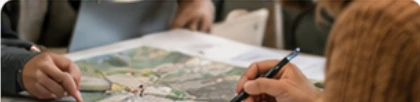 Hands examining a geographic map and planning regional activities